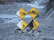 Signs warning of the hazards of a glacier in New Zealand