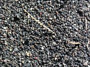 Close up of black volcanic sand from Perissa, in Santorini, Greece