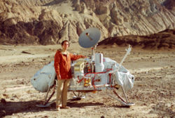 Sagan with a model of the Viking Lander probes which would land on Mars. Sagan examined possible landing sites for Viking along with Mike Carr and Hal Masursky.