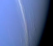 A band of high altitude clouds is shown casting shadows on Neptune's lower cloud deck.