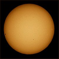 Transit of Mercury. Mercury is the small dot in the lower center, in front of the sun. The dark area on the left of the solar disk is a sunspot.