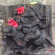 Ganesha riding on his mouse. A sculpture at the Vaidyeshwara temple in Talakkadu, Karnataka, India. Note the red flowers offered by devotees.