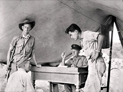 October 26, 1945, Sandakan, North Borneo. During the investigation into Sandakan Death Marches and other incidents, Sergeant Hosotani Naoji (left, seated), a member of the Kempeitai unit at Sandakan, is interrogated by Squadron Leader F. G. Birchall (second right) of the Royal Australian Air Force, and Sergeant Mamo (right), a Nisei member of the U.S. Army/Allied Translator and Interpreter Service. Naoji confessed to shooting two Australian POWs and five ethnic Chinese civilians.