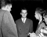 Feynman (center) with Robert Oppenheimer (right) relaxing at a Los Alamos social function during the Manhattan Project.