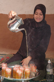 Moroccan tea being served. It is poured from a distance to produce a foam on the tea.