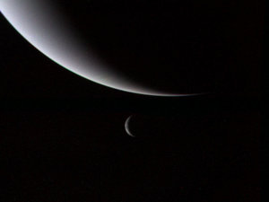 Photograph of the planet Neptune (large, background) and its moon Triton (small, foreground), taken by Voyager 2 as it entered the outer Solar System.