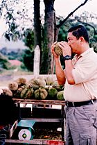 A customer sniffs durian before purchasing it.