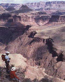 Two hikers looking down on the Grand Canyon