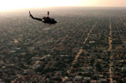 Aerial view of a residential area of Mogadishu, with a U.S. Marine Corps helicopter in the foreground, December 1992.