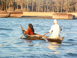 A man and woman make their way up the Shatt-al-Arab in Basra, Iraq.