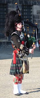 A piper playing the Great Highland Bagpipe.
