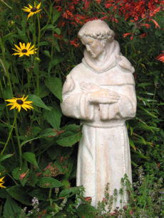 A garden statue of Francis of Assisi with birds
