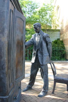 A statue of Digory Kirke (C. S. Lewis's fictional alter ego from The Magician's Nephew) in front of the wardrobe of his book The Lion, the Witch and the Wardrobe in East Belfast, Northern Ireland