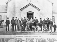 Members of the Legislative Assembly stand outside the legislature in Regina circa 1886.