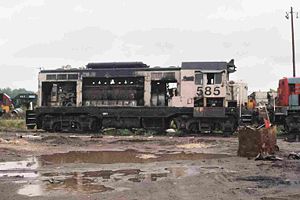 Former Amtrak CF7 #585 rests in a salvage yard on September 19, 2003. The side doors have been removed, exposing its prime mover and other mechanical components. The unit had also been fitted with roof-mounted "torpedo tube" air tanks to accommodate the enlarged fuel and water tanks that facilitated its use in passenger service.