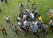 Indonesians gather under an approaching helicopter to receive food and supplies.