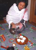 Coffee farmer filling cups with coffee