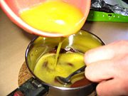 Mixing dissolved butter with chocolate to make a brownie