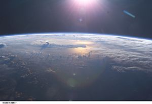 Sunset over the Pacific Ocean as seen from the International Space Station. Anvil tops of thunderclouds are also visible.