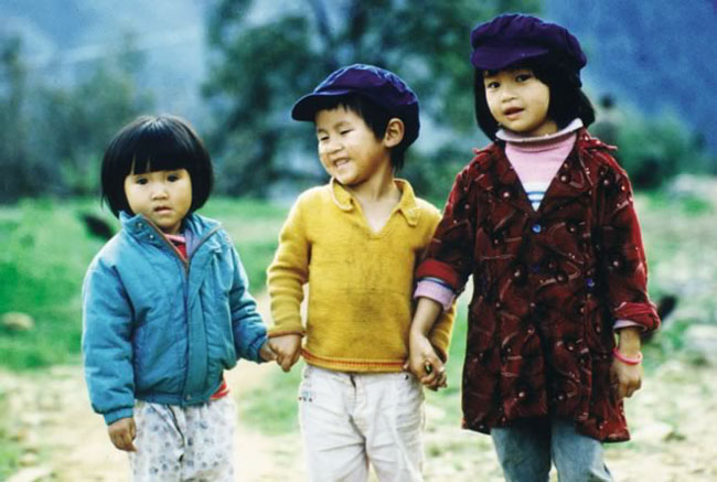 Three children holding hands in Vietnam