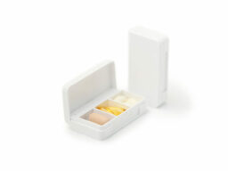 White pill box with yellow pills inside