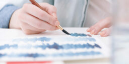 a person watercoloring with blue paints