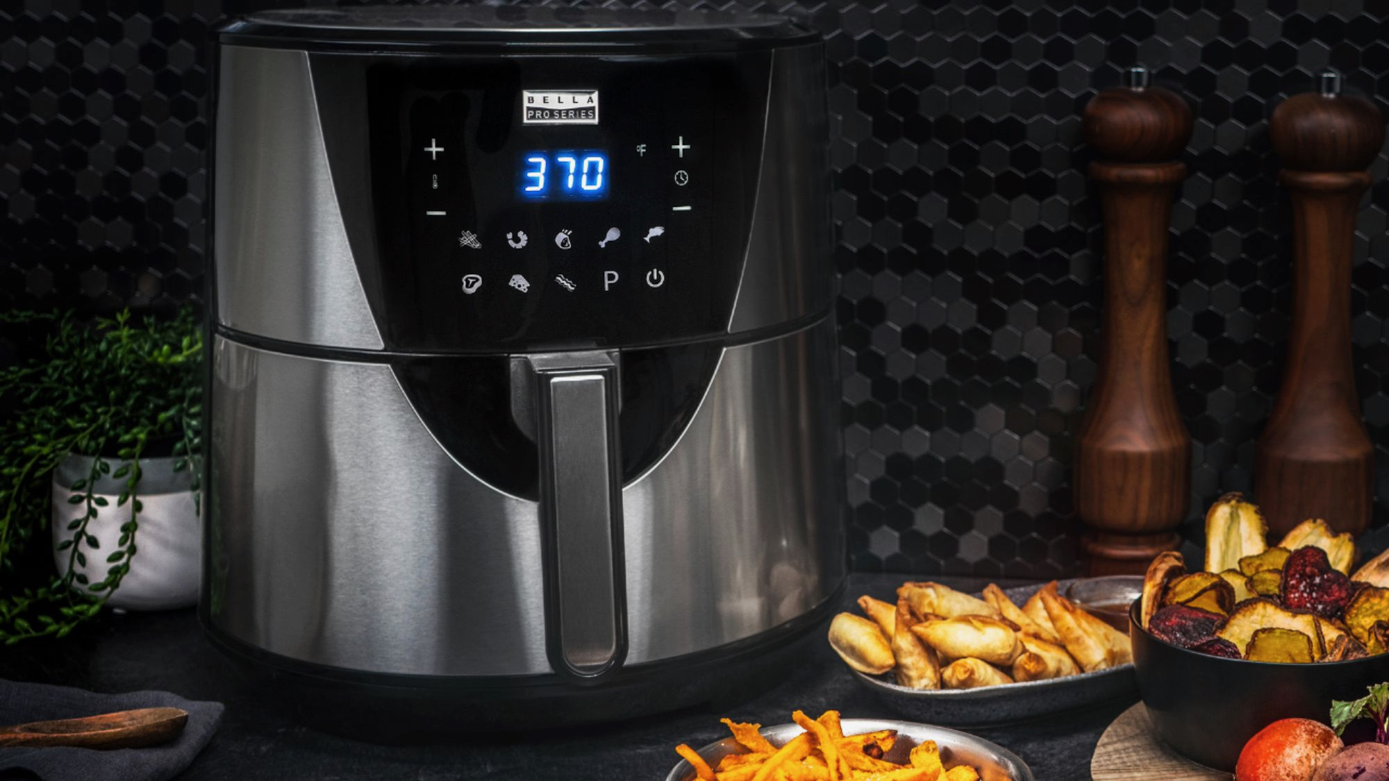 an air fryer next to dishes of food
