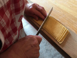 Hands with knife cutting dough