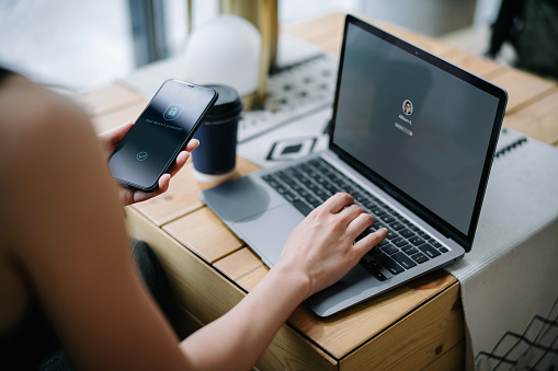 woman holding a phone and securing her laptop