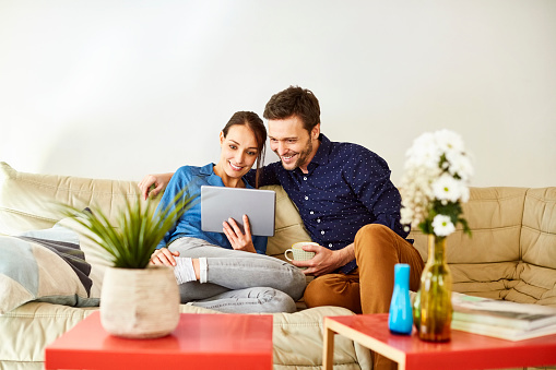 couple sitting on the couch looking at a laptop together