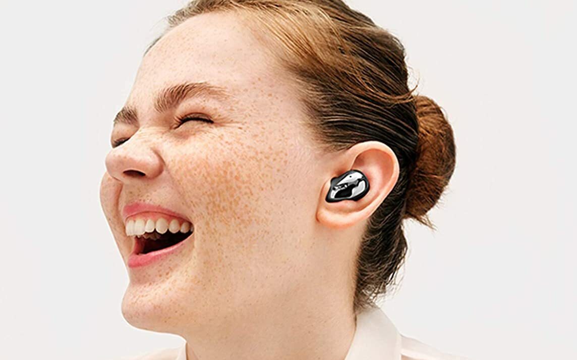 Girl laughing with earbuds in
