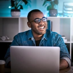 man smiling in front of computer