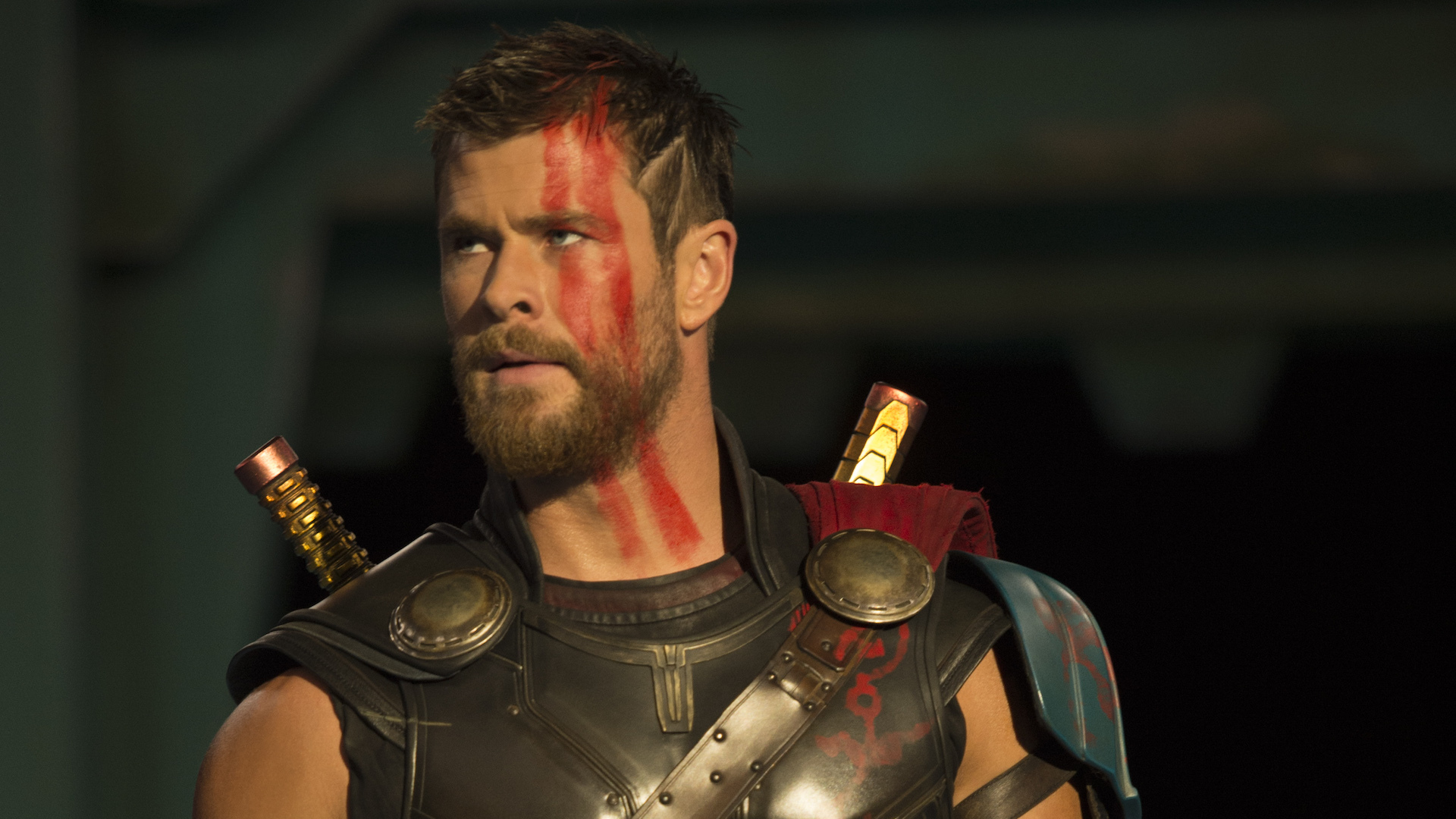 A close up of Chris Hemsworth as Thor Odinson, with short hair and red war paint on his face.
