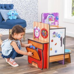 Little girl playing with toy kitchen set