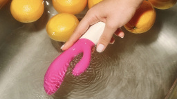 a pink and white lelo ina wave 2 in water with lemons