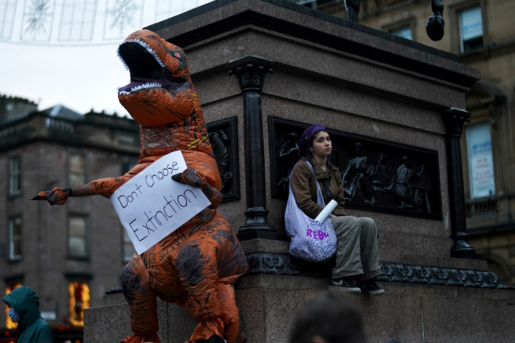 A protester dressed up as a dinosaur begs world leaders to stop "choosing extinction" for the planet.