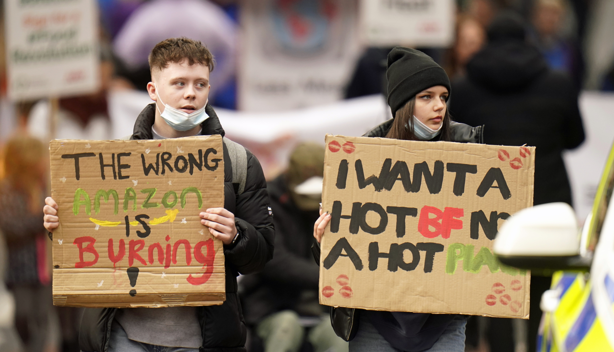 Two protesters hold signs as they march to George Square.