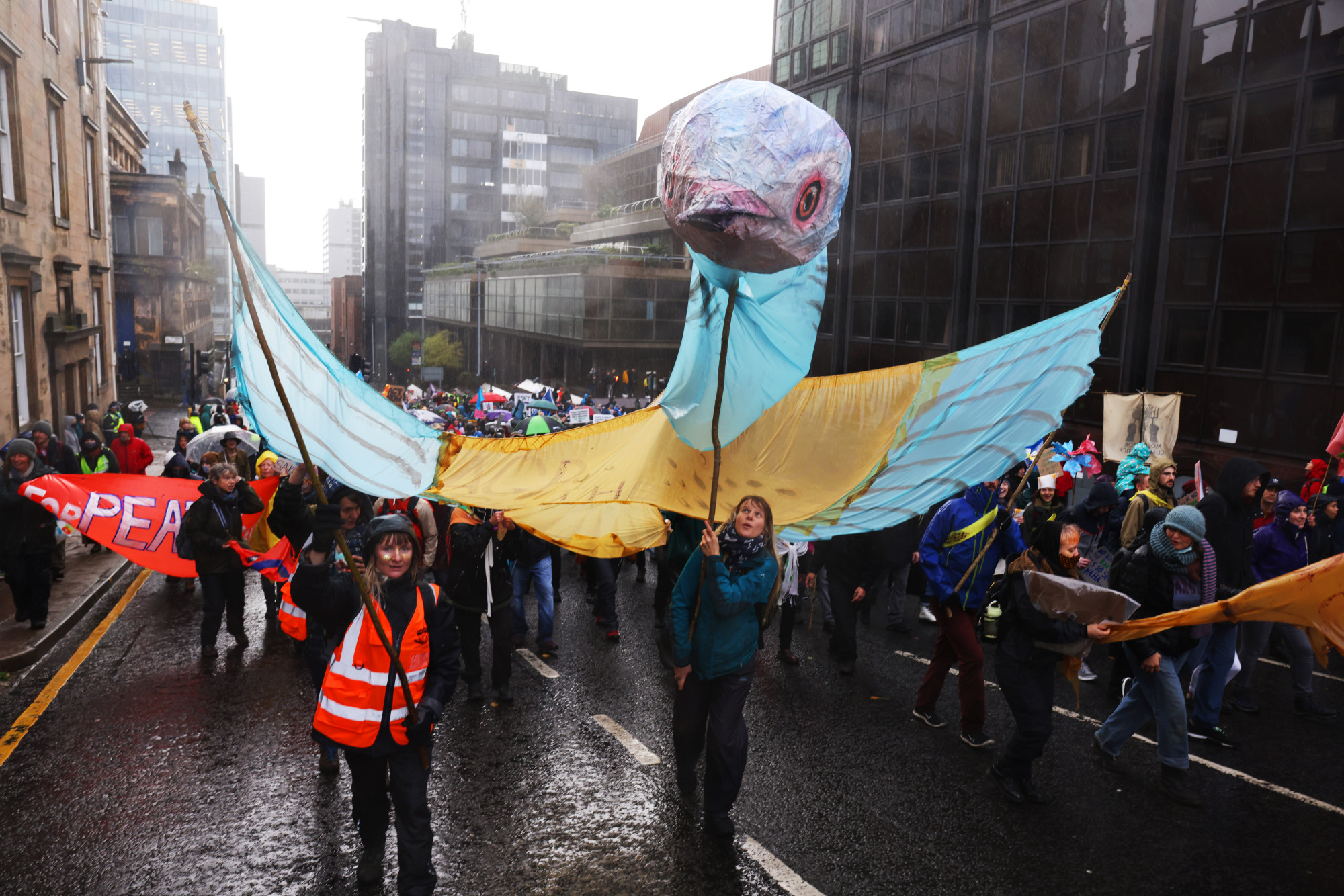 Demonstrators carry a paper bird sculpture in Glasgow.