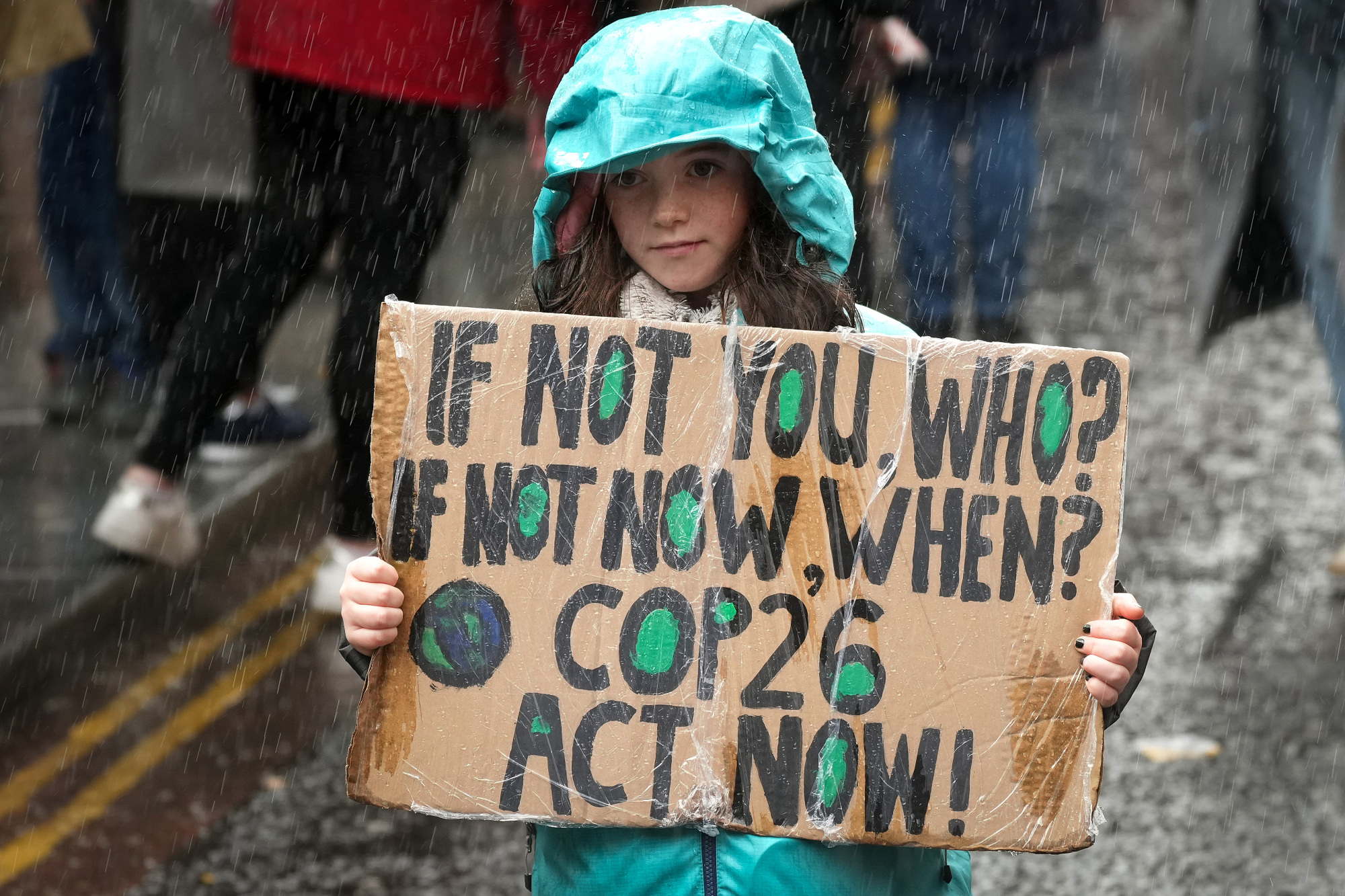 Protesters hold powerful signs calling for action in Glasgow.