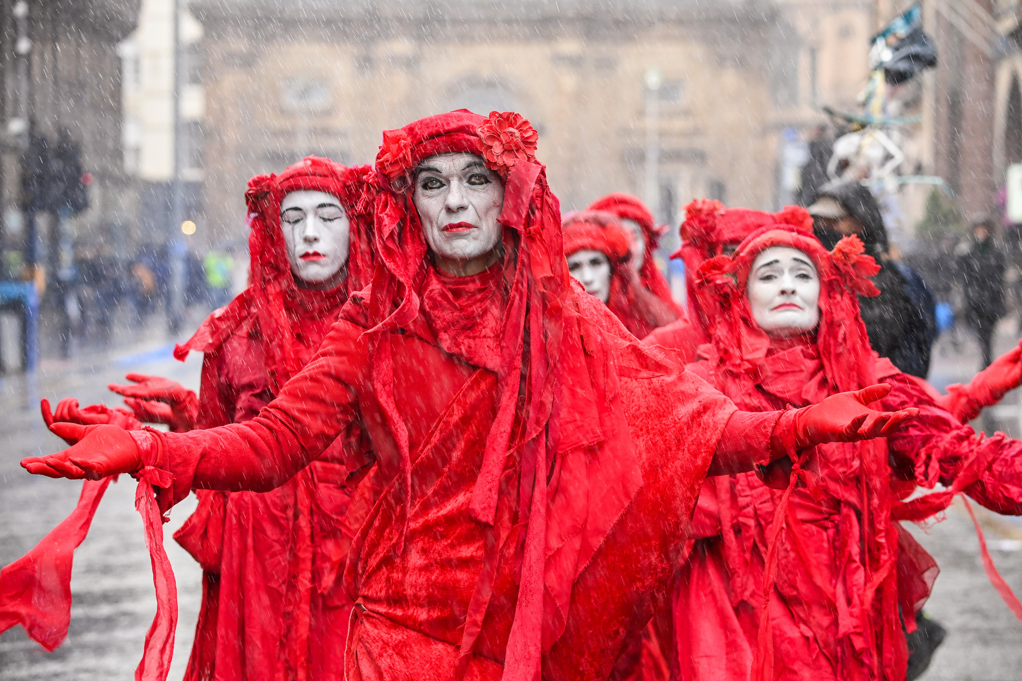 The Red Rebels, an international performance artivist troupe dedicated to fighting the climate crisis, attend the protest in Glasgow.