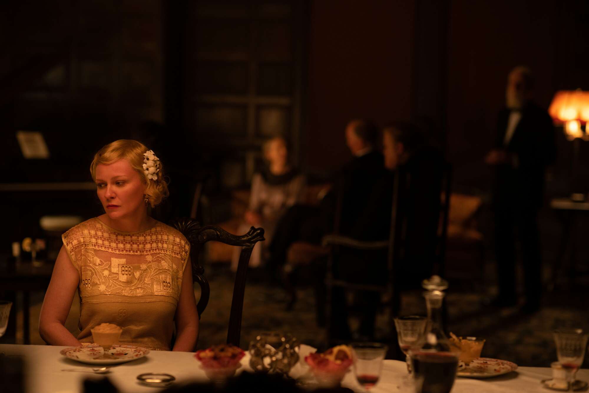 Kirsten Dunst looks sad in dinner scene from 'The Power of the Dog.' 