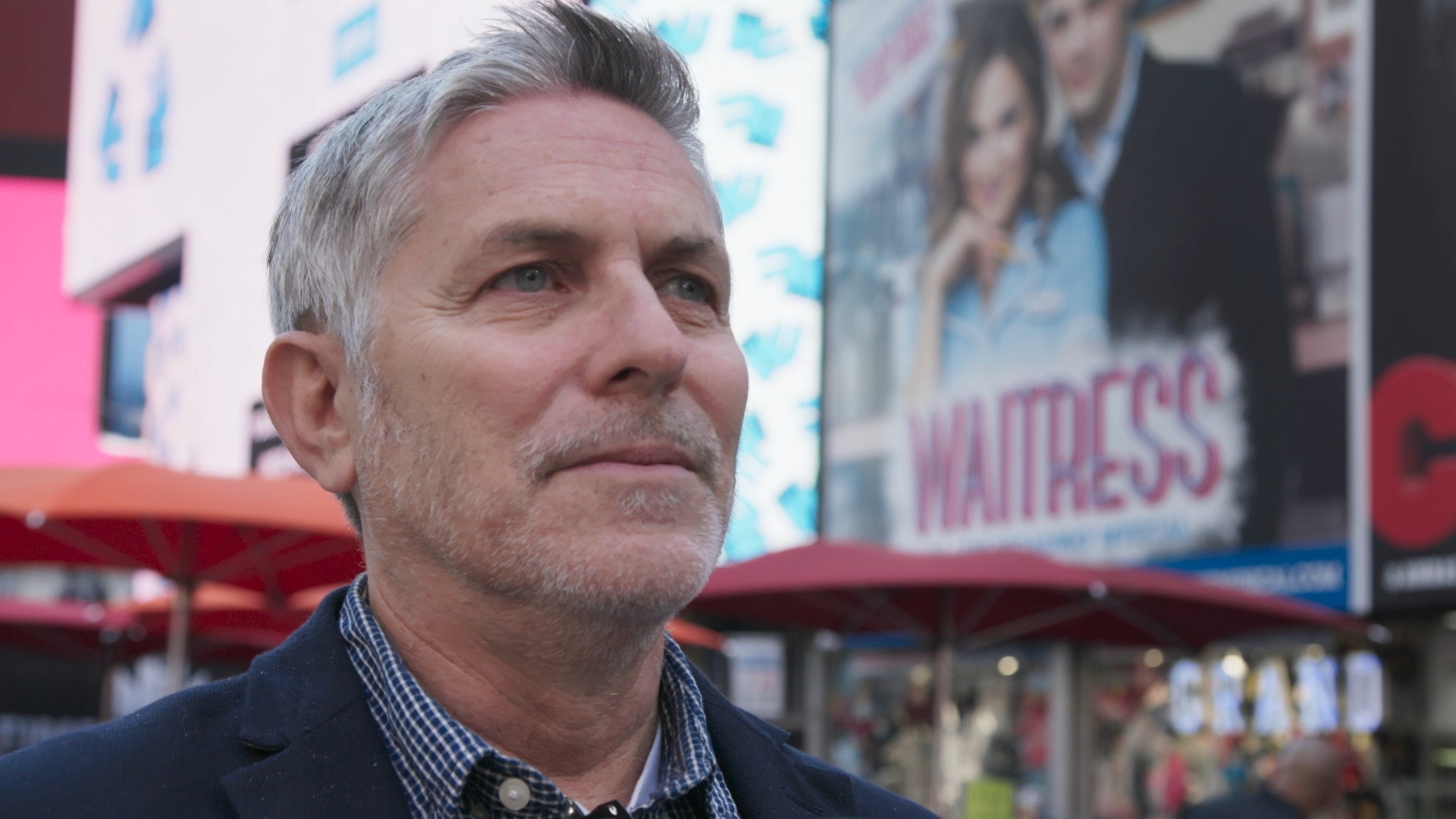 Andy Ostroy walking through Times Square in 'Adrienne'.