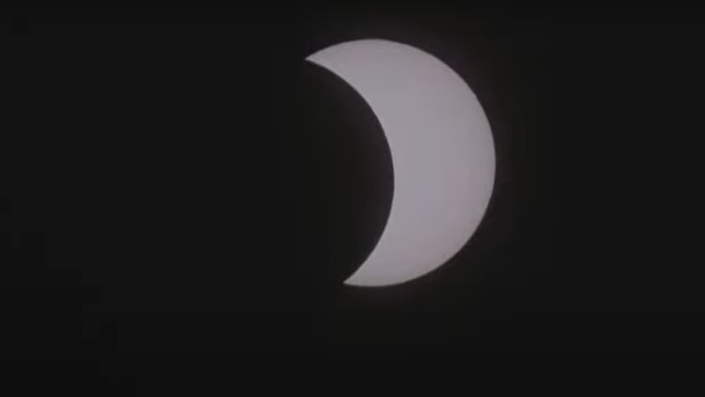 the moon moving in front of the sun during a total solar eclipse