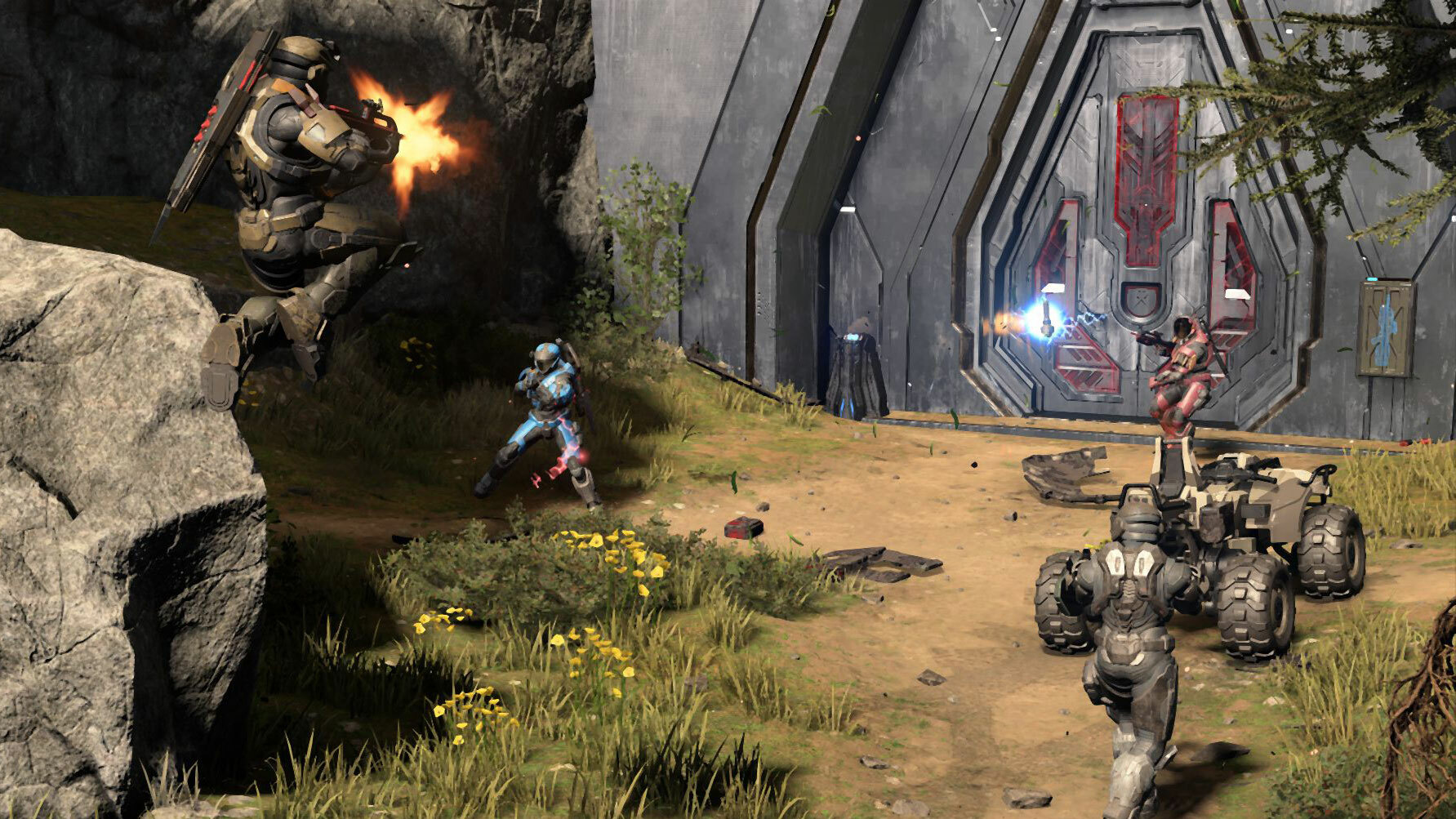 A screenshot from Halo Infinite's multiplayer mode featuring multiple Spartan space marines fighting in front of a closed sliding metal door set into the side of a mountain.