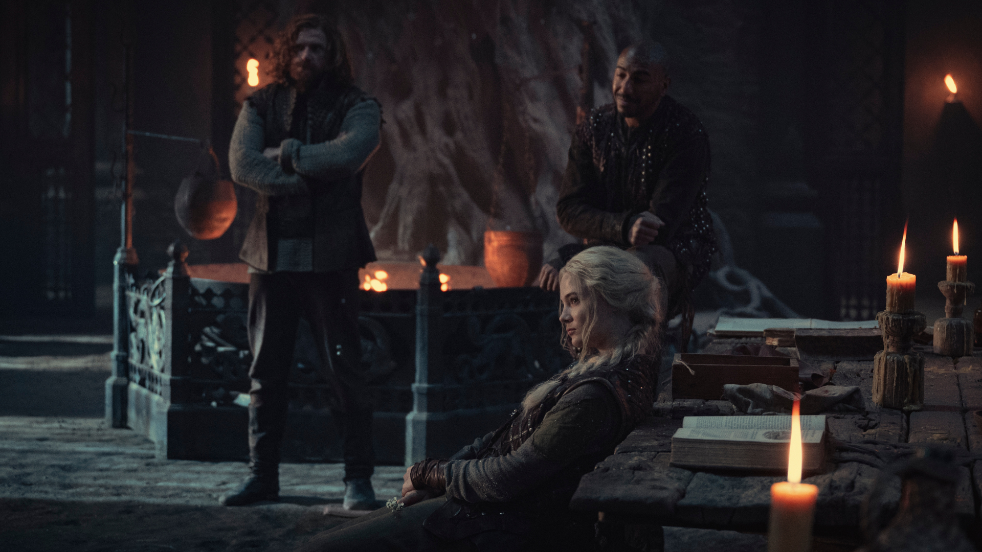 Three people sit in a fantasy-style pub.