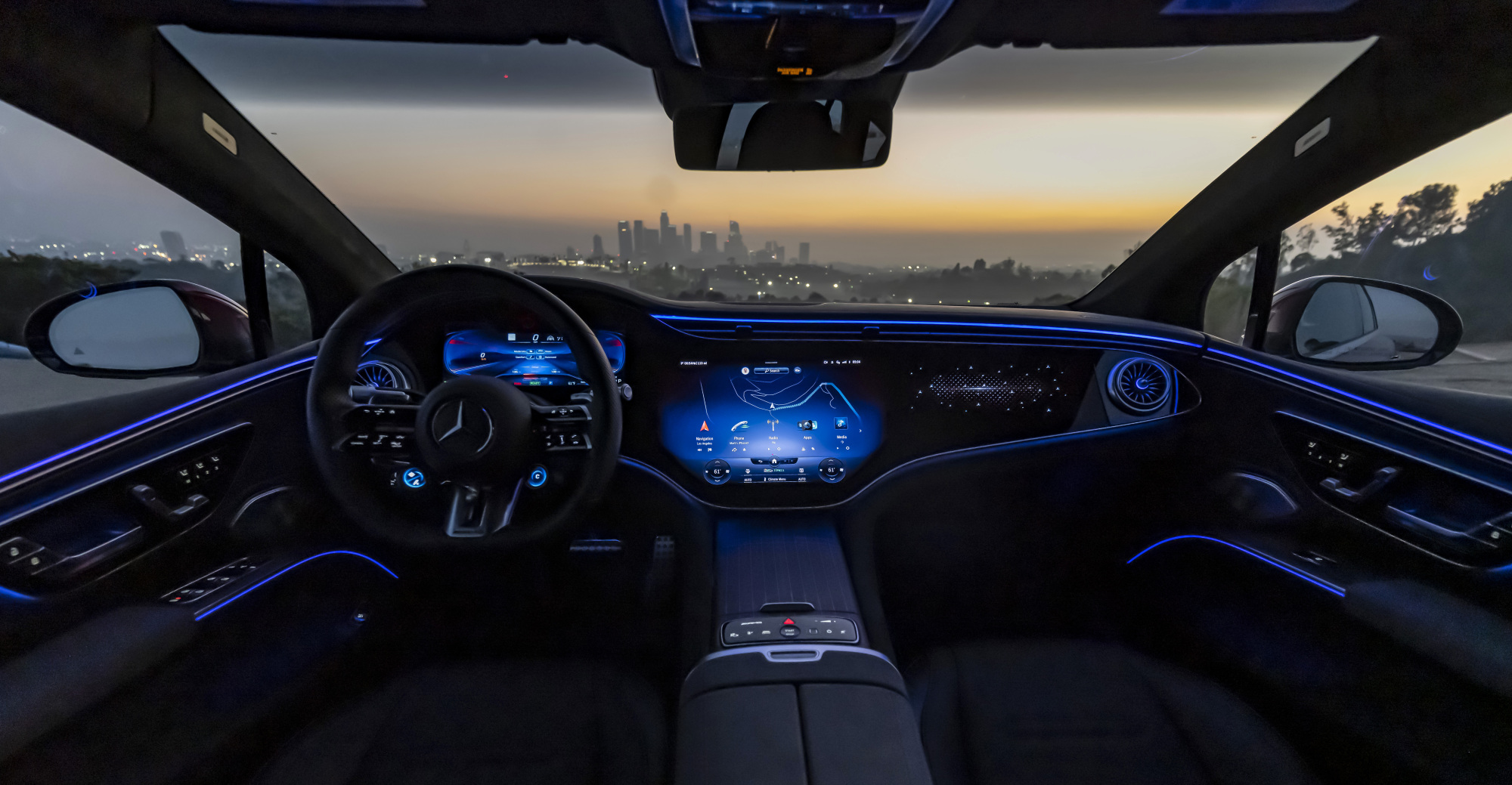 Los Angeles skyline in the background through the windshield of the car.