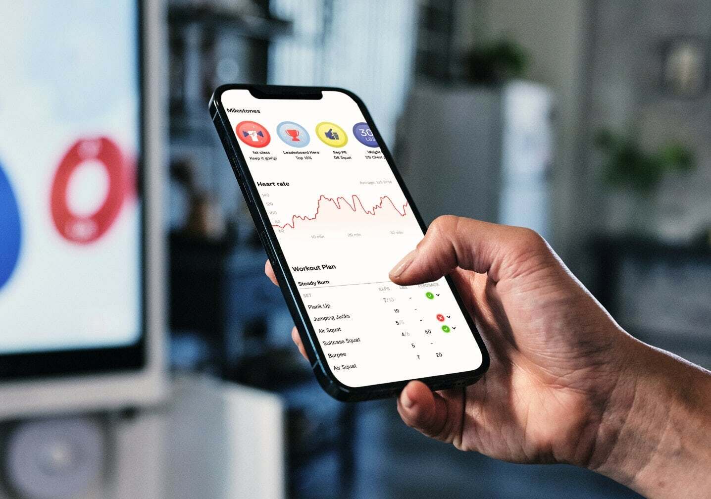 Someone holding a smartphone with app interface tracking heart rate