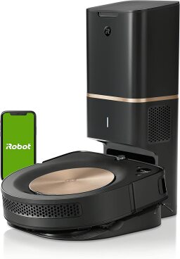 Black roomba in charging station next to phone with irobot app