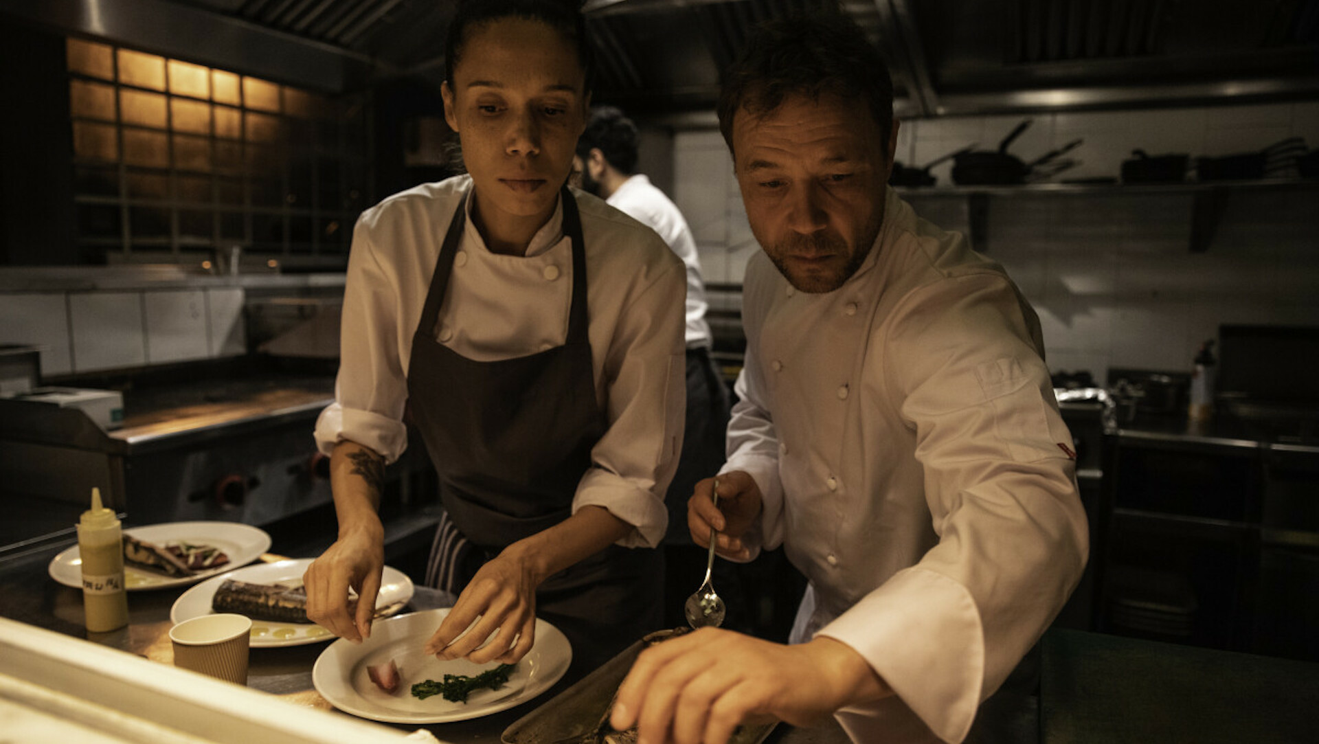Two chefs in a kitchen in the film "Boiling Point."