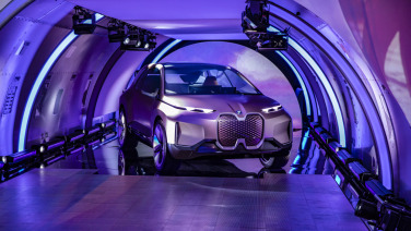 Purple hues surround a car parked in a tunnel space.